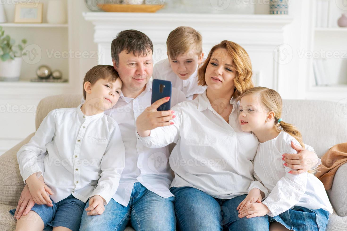 familia caucásica sentada en un sofá en la sala de estar en casa. madre padre pequeño foto