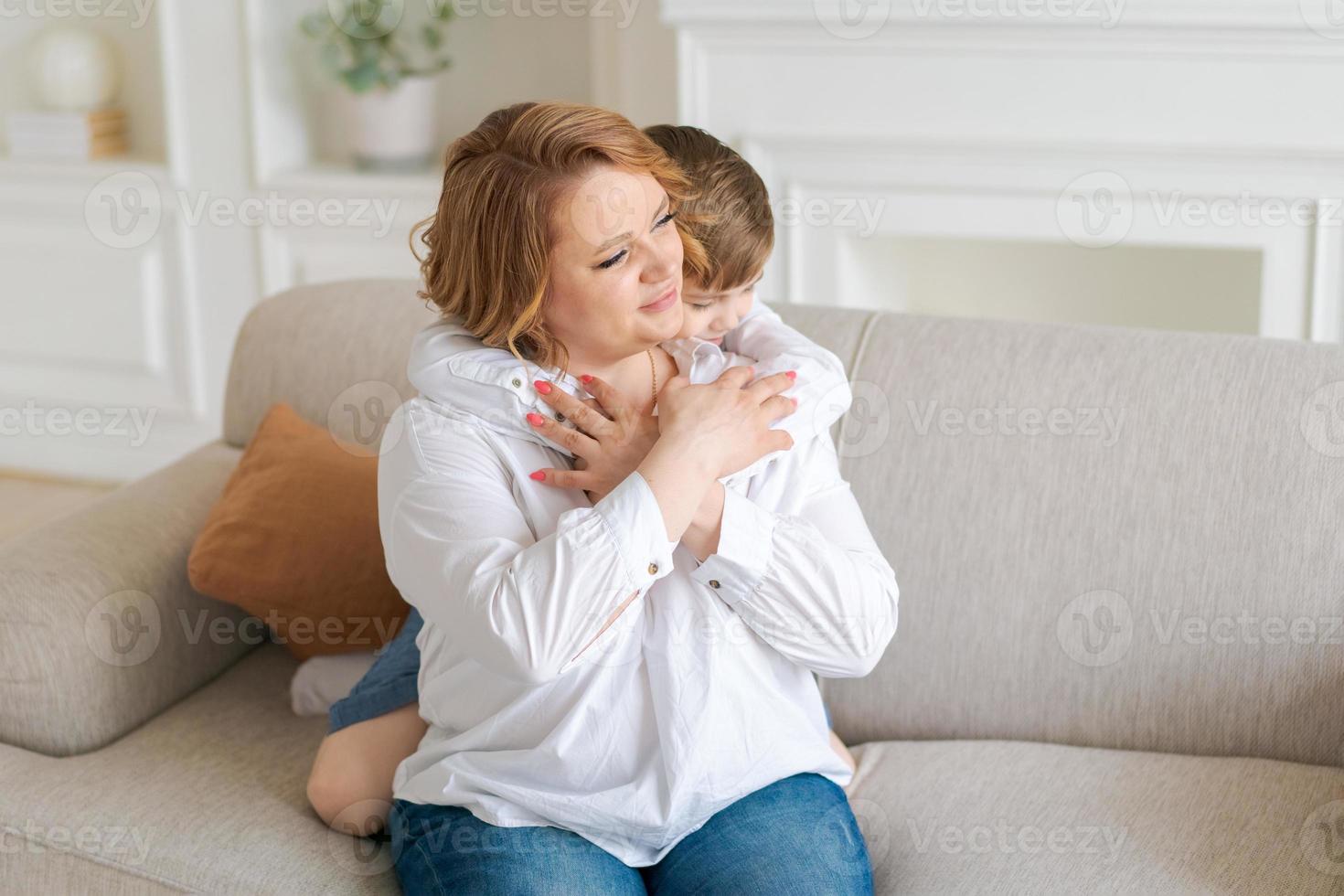 Happy young caucasian mother hugs cute little preschool son together at home photo