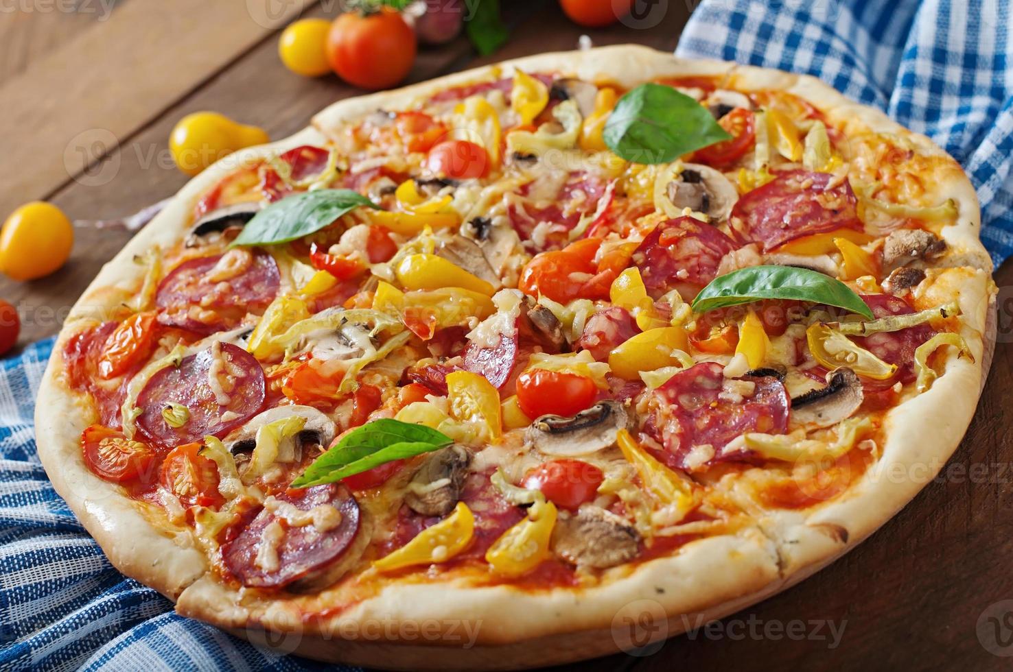 Pizza with salami, tomato, cheese and mushrooms photo