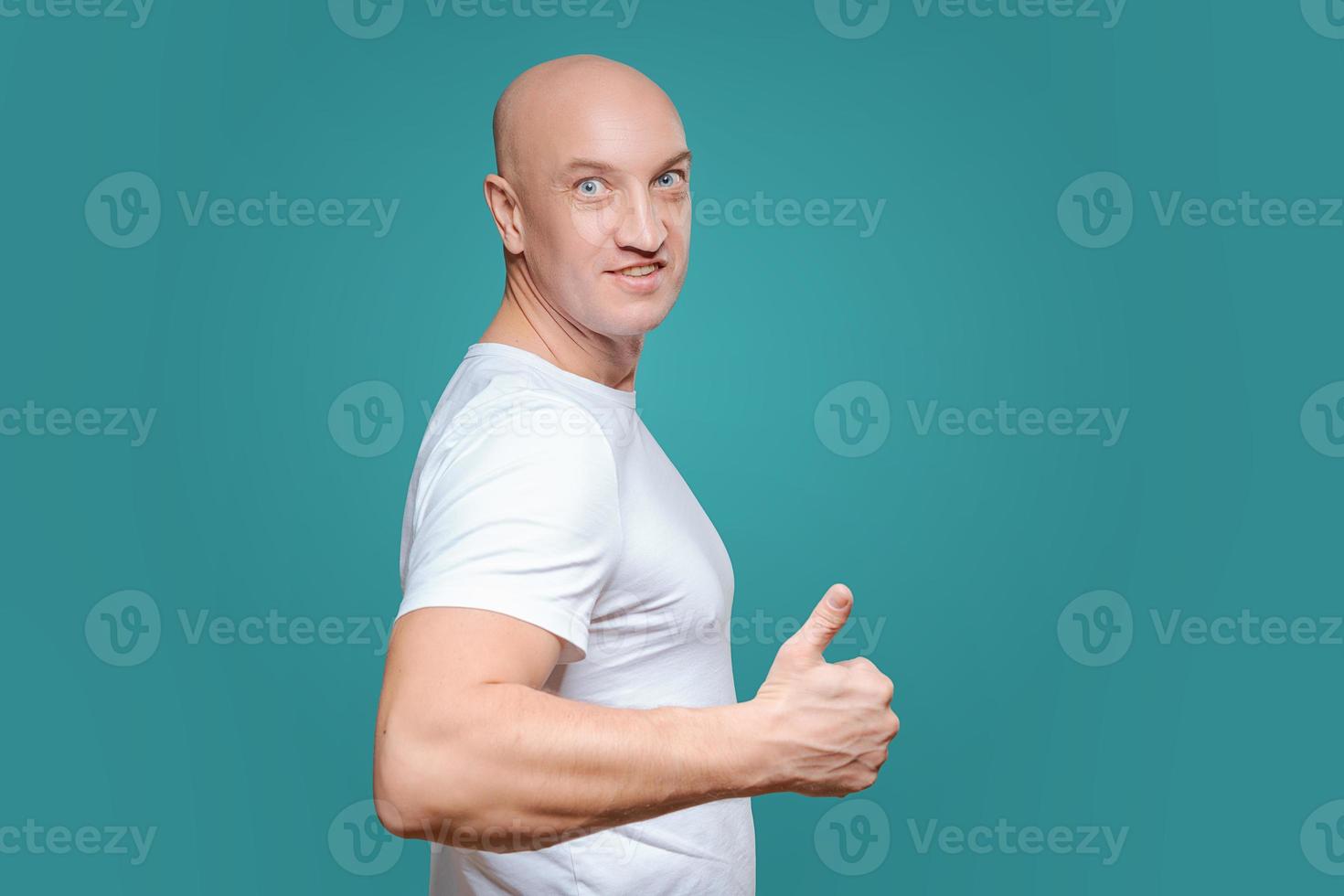 an emotional man in a white t-shirt shows with a hand gesture that everything is cool, on a Titian background photo