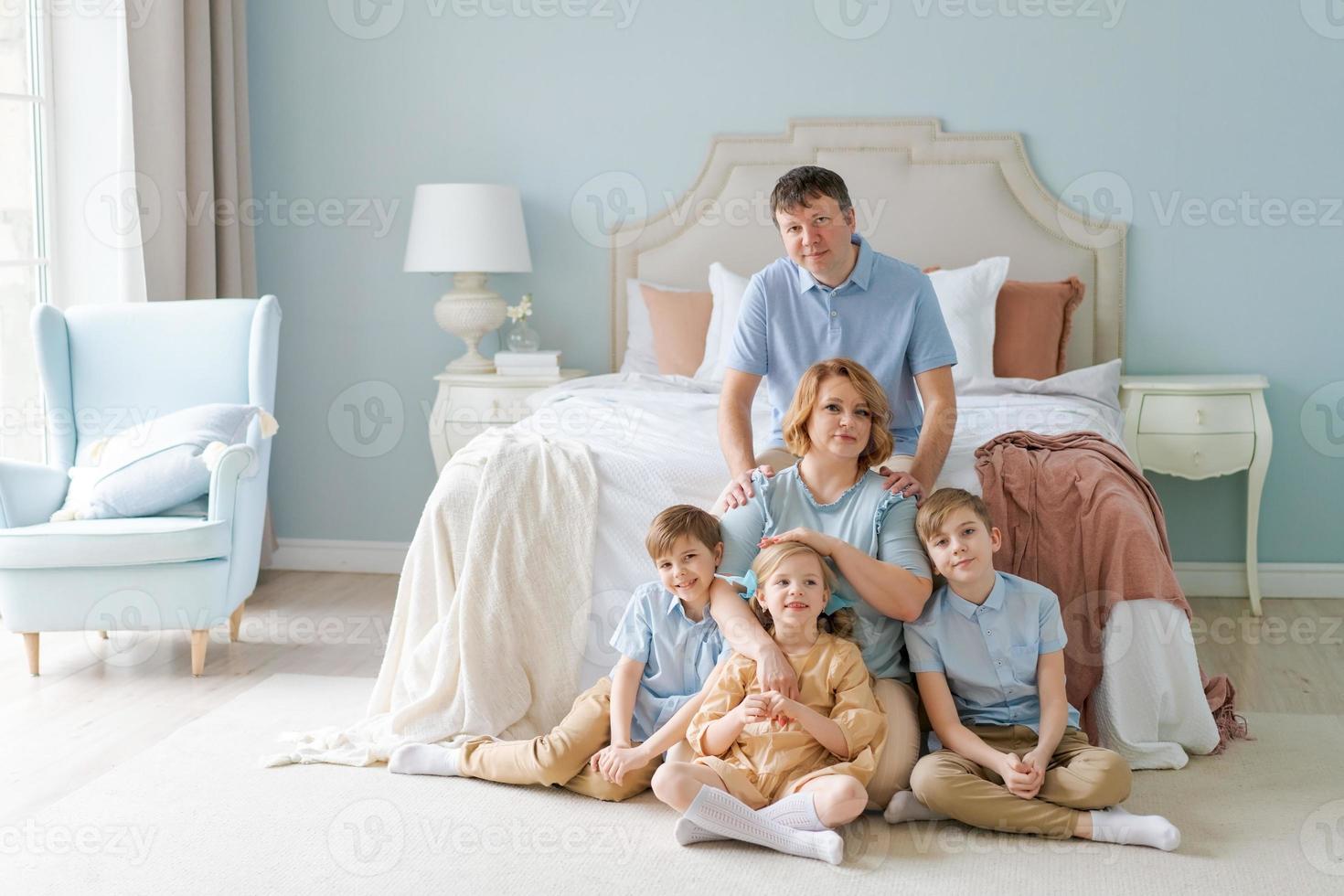 Portrait large family five people father mother two sons and daughter lying photo