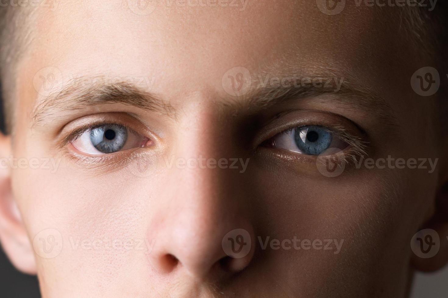 Portrait of a guy close up looking at the camera with blue eyes photo