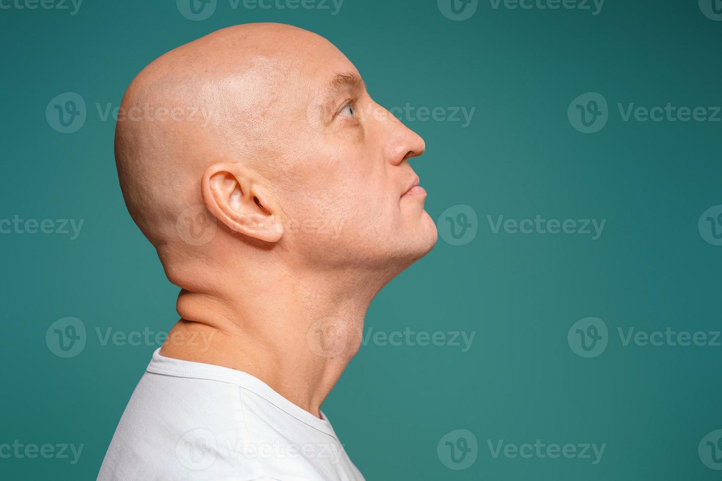 portrait of a bald man in a white t-shirt on the background, facial expression photo