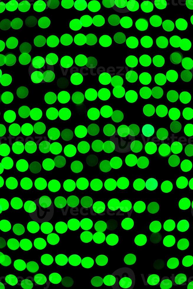 Unfocused abstract green bokeh on black background. defocused and blurred many round light photo