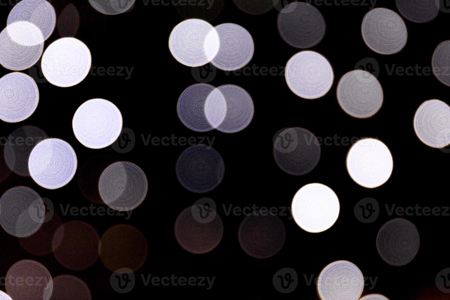 Abstract bokeh of white city lights on black background. defocused and blurred many round light photo
