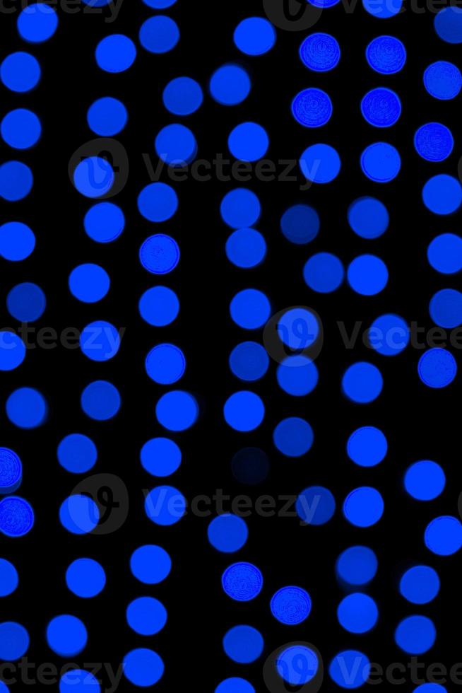 Unfocused abstract dark blue bokeh on black background. defocused and blurred many round light photo