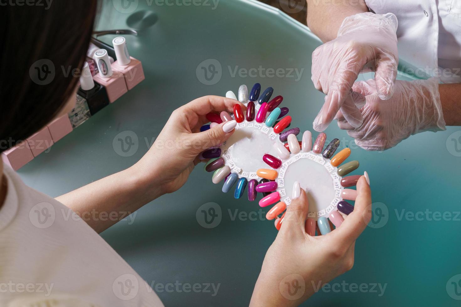 Beauty saloon. Master together with client, chooses color of gel polish photo