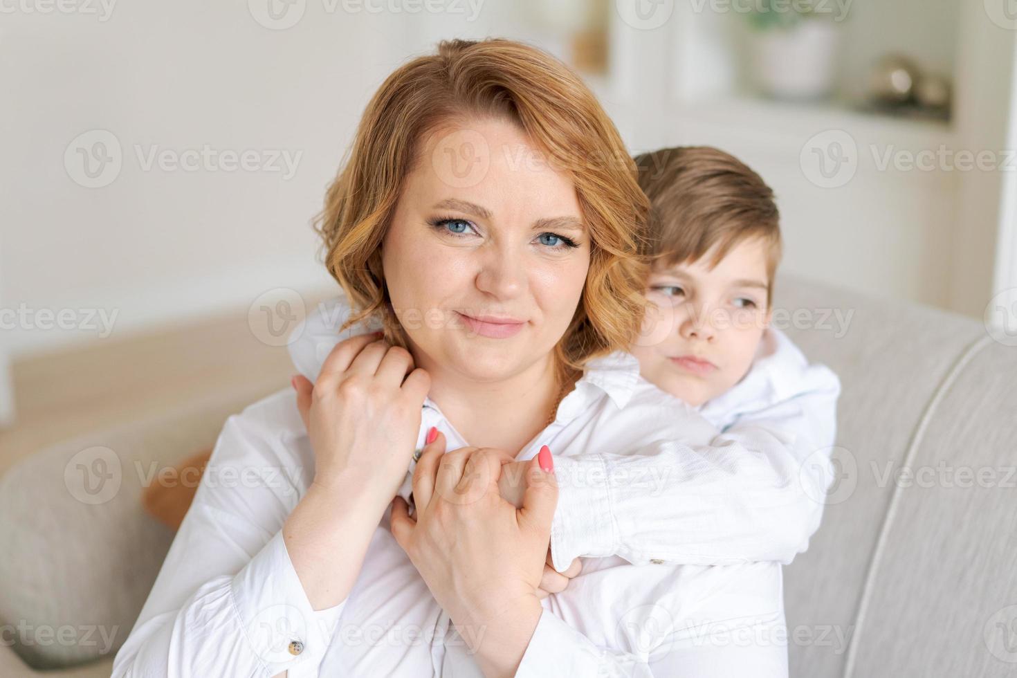 Happy woman have fun with cute baby boy 5-6-7 years old in white shirt. Mom photo