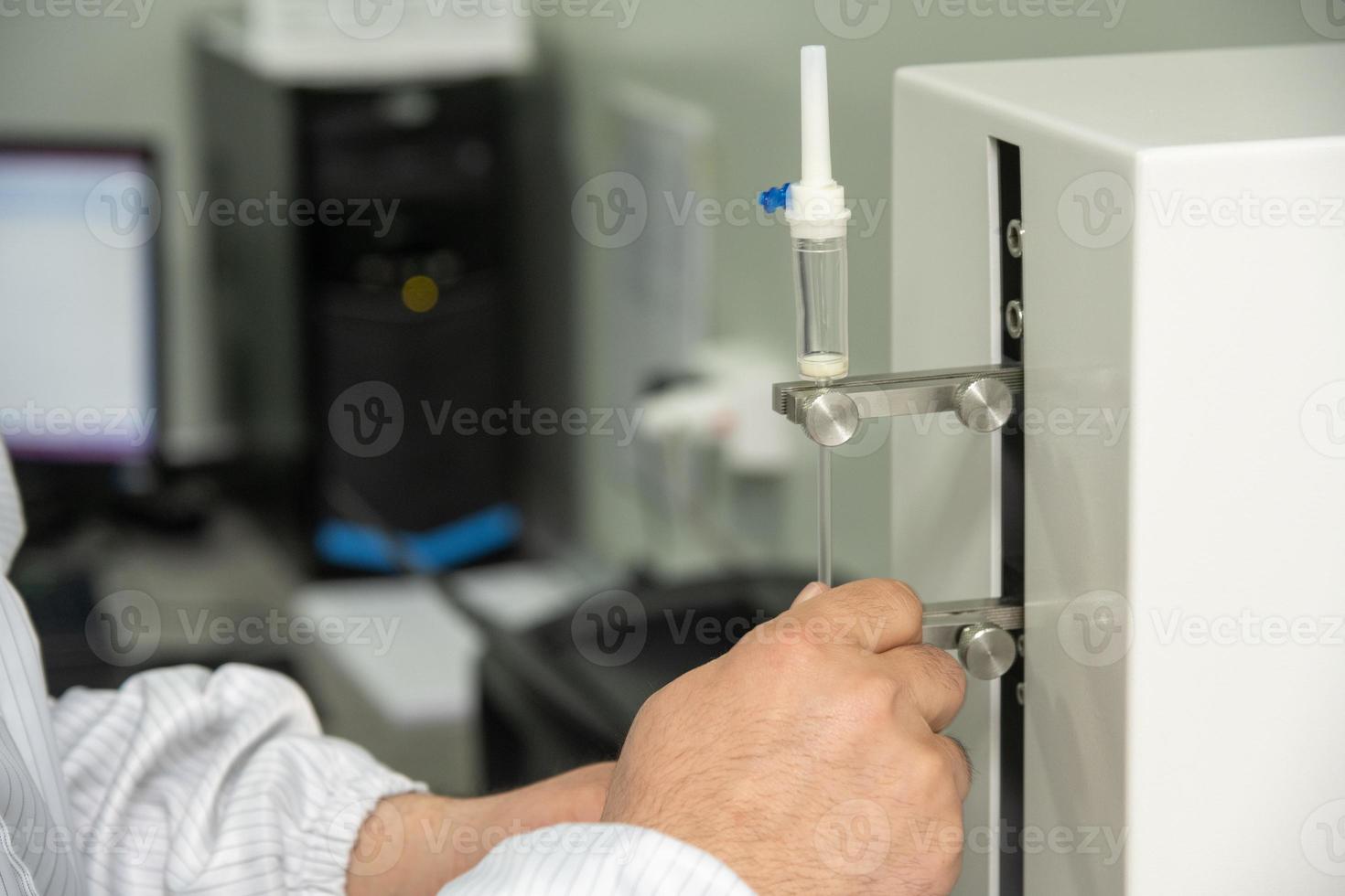 A closeup shot of hands working on a machine in a medical production warehouse for syringes photo