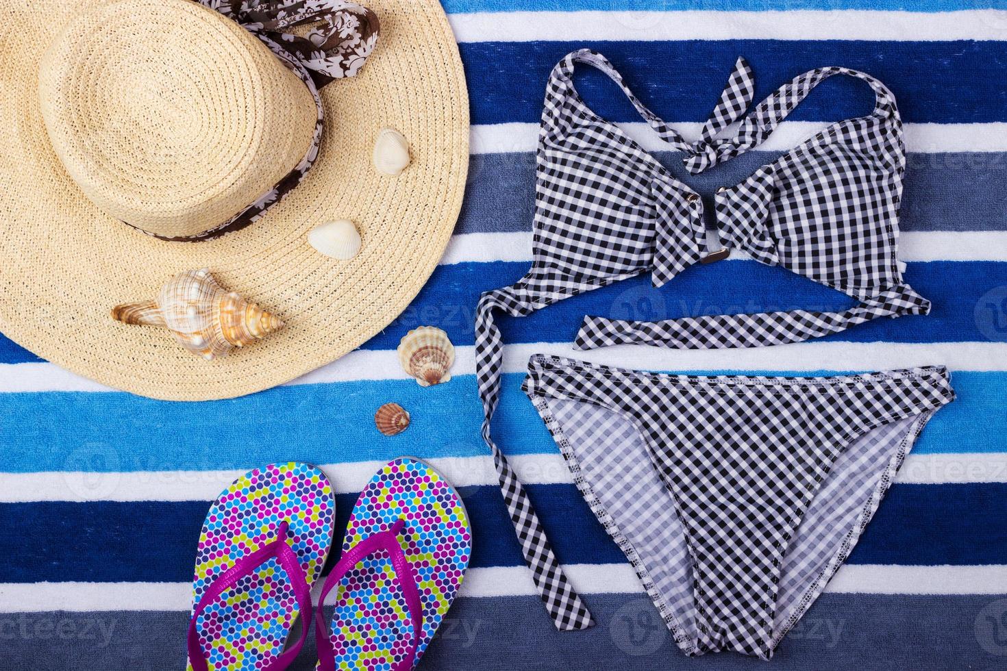 Summer background with straw hat, flip flops and swimsuit. Top view photo