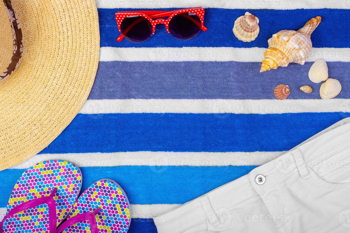 Straw Beach Woman's Hat Sun Glasses Top View Seashell Shorts Flip flops with space for text. photo