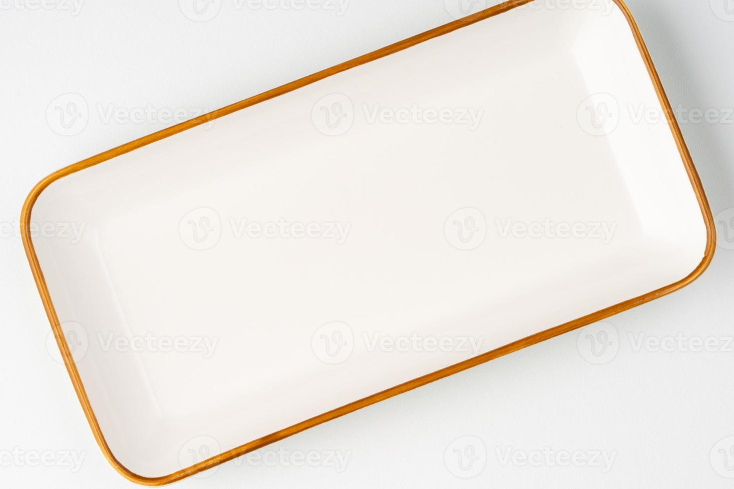 A white ceramic rectangular serving tray with an orange outline. Top view photo