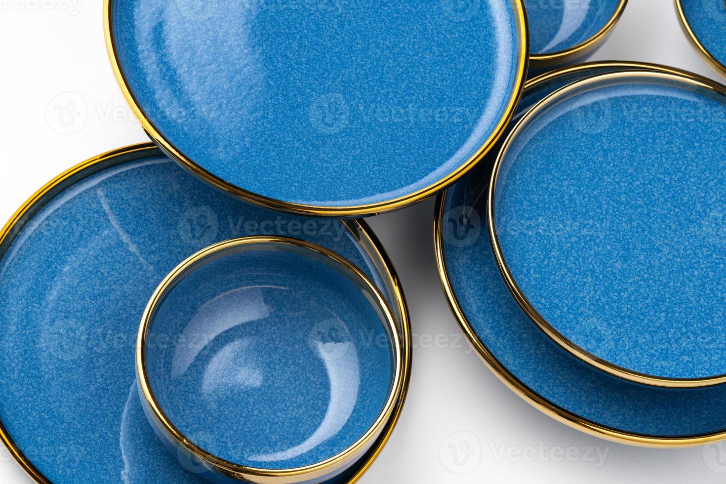 A set of blue ceramic plates on a white background. Top view photo