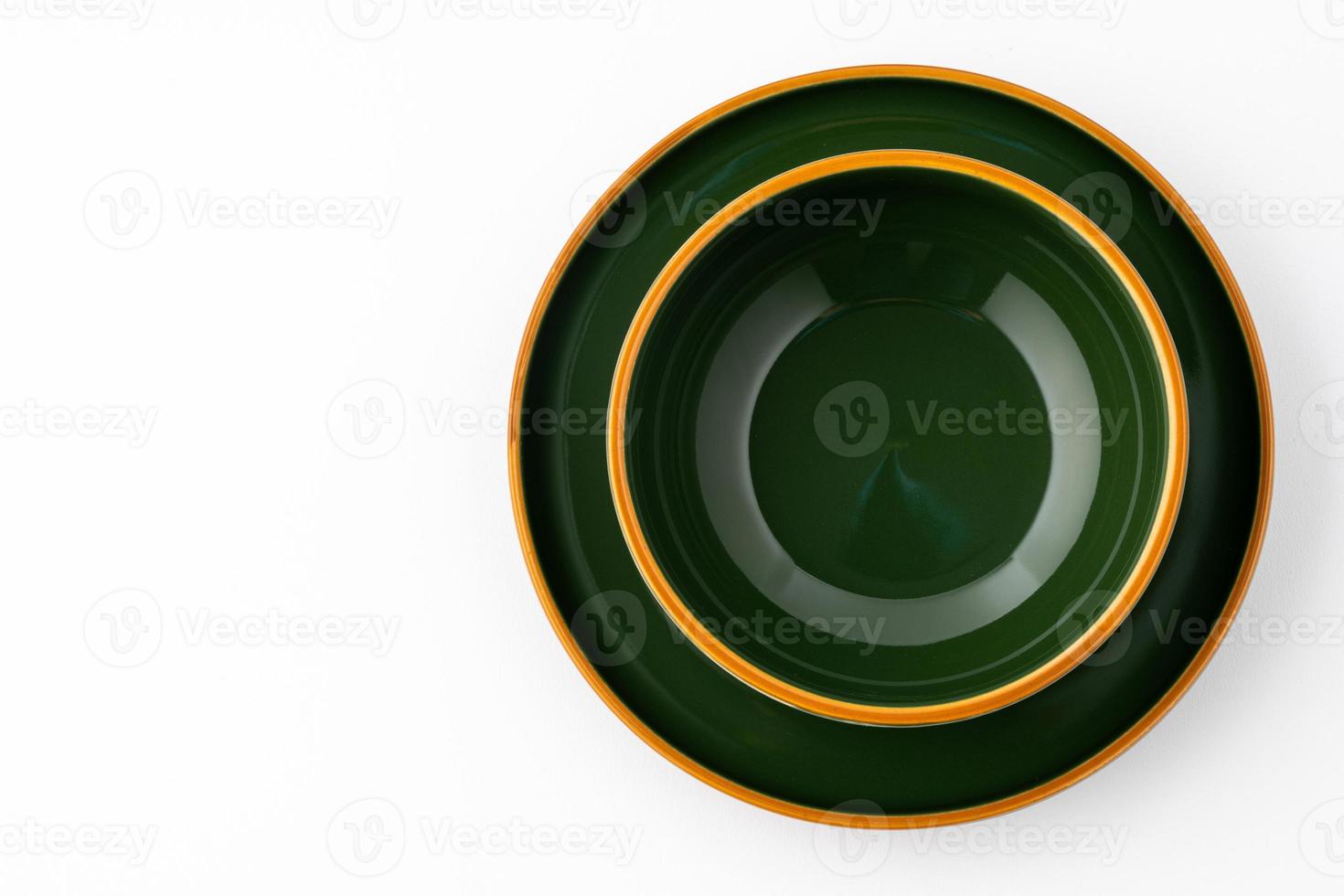 A set of dark green ceramic tableware with orange outlines on a white background photo