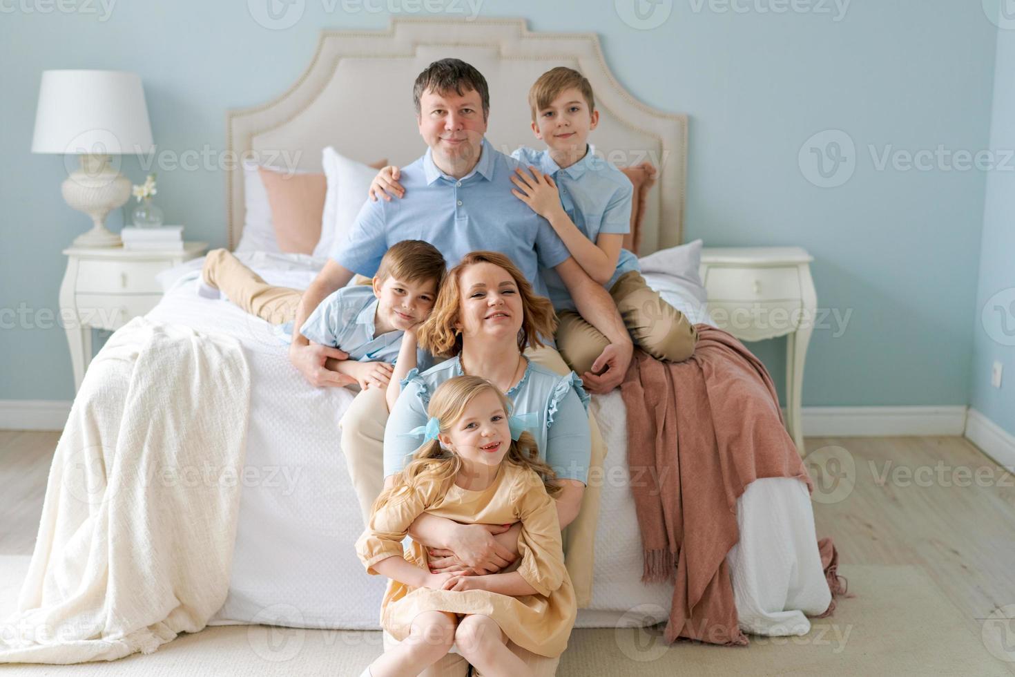 Happy caucasian big family with cute kids sit in bedroom by bed, children laugh photo