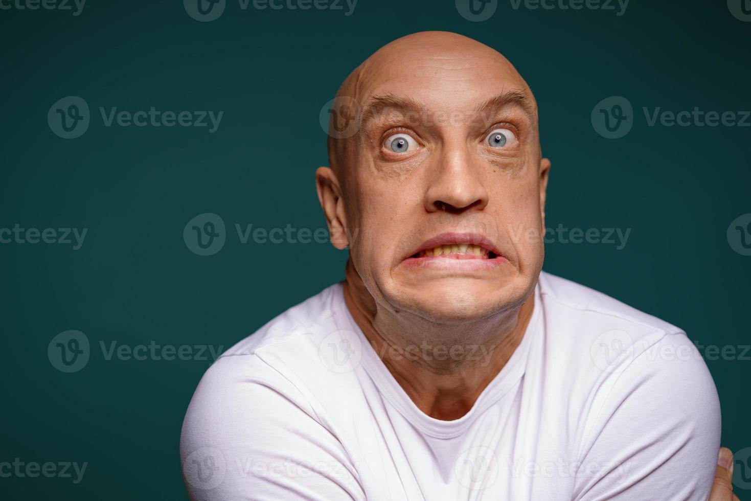 bald man with facial expressions on a blue background photo