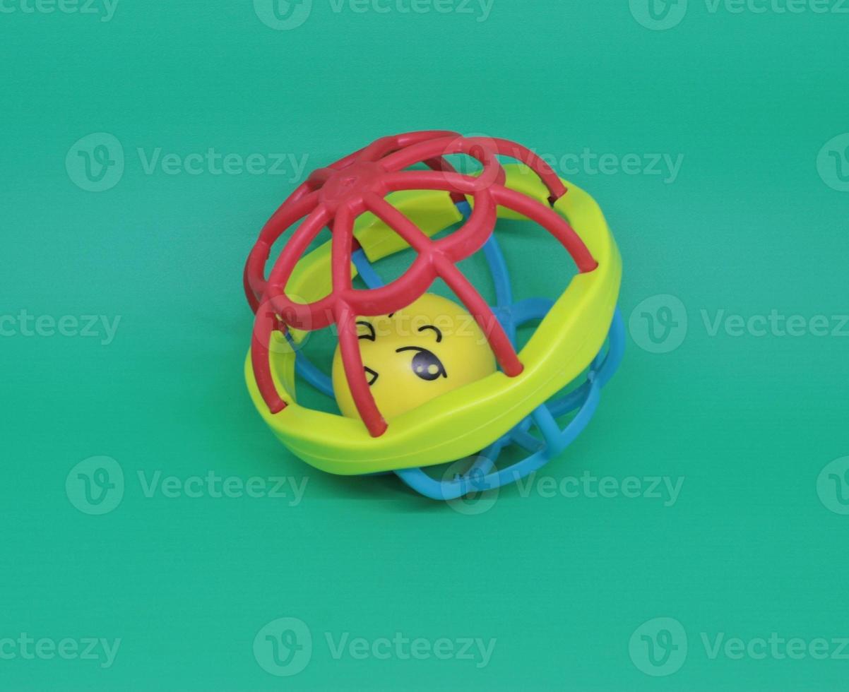 colorful baby rattles or teethers isolated on green background photo