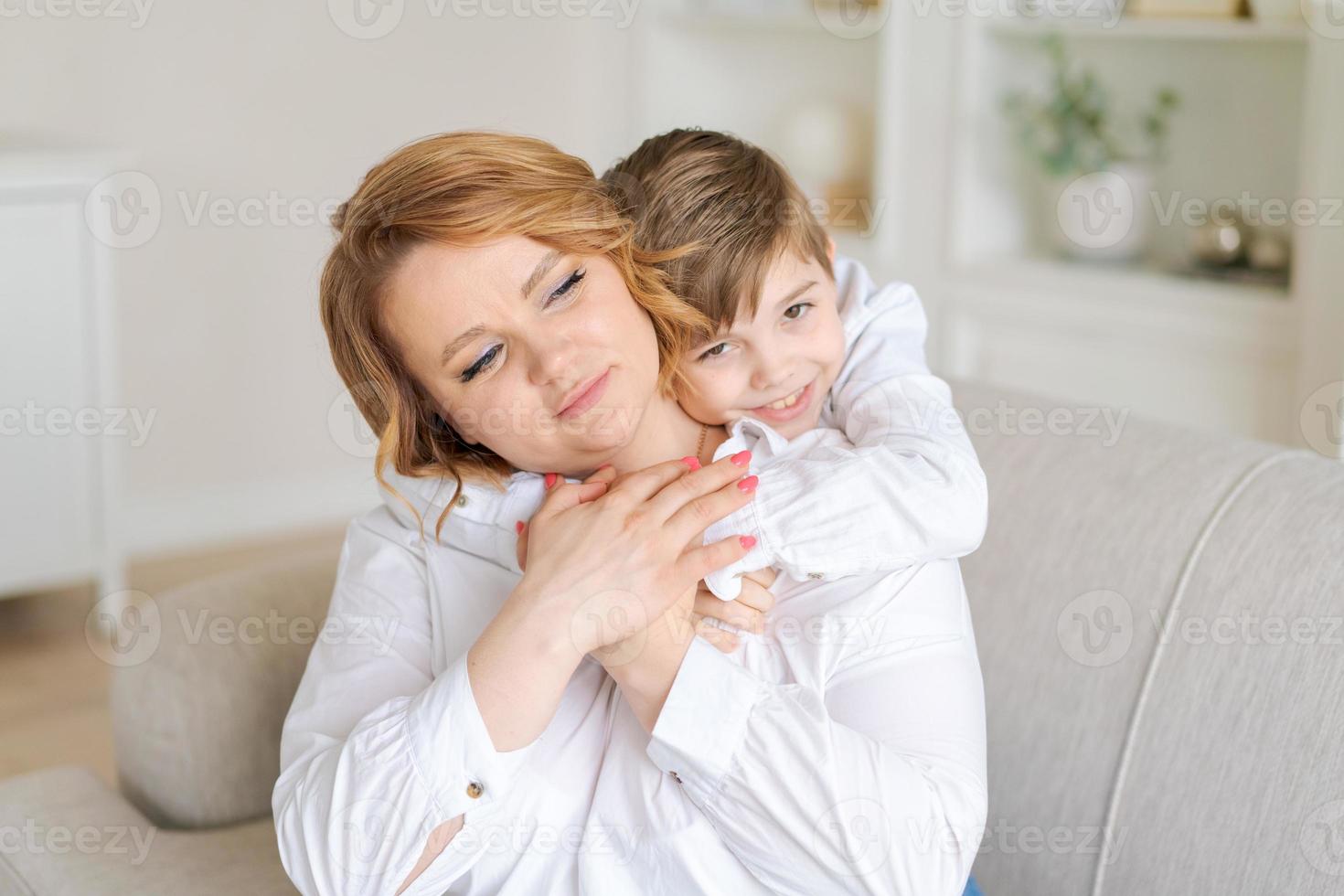 disparo a la cabeza feliz joven abrazando hablando con un hijo pequeño divirtiéndose juntos foto