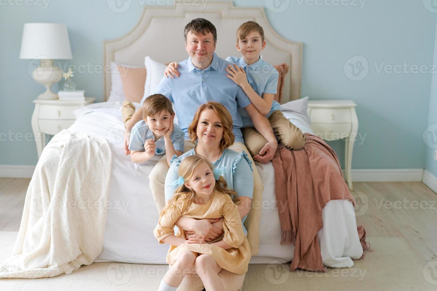 Portrait large family five people father mother two sons and daughter lying photo