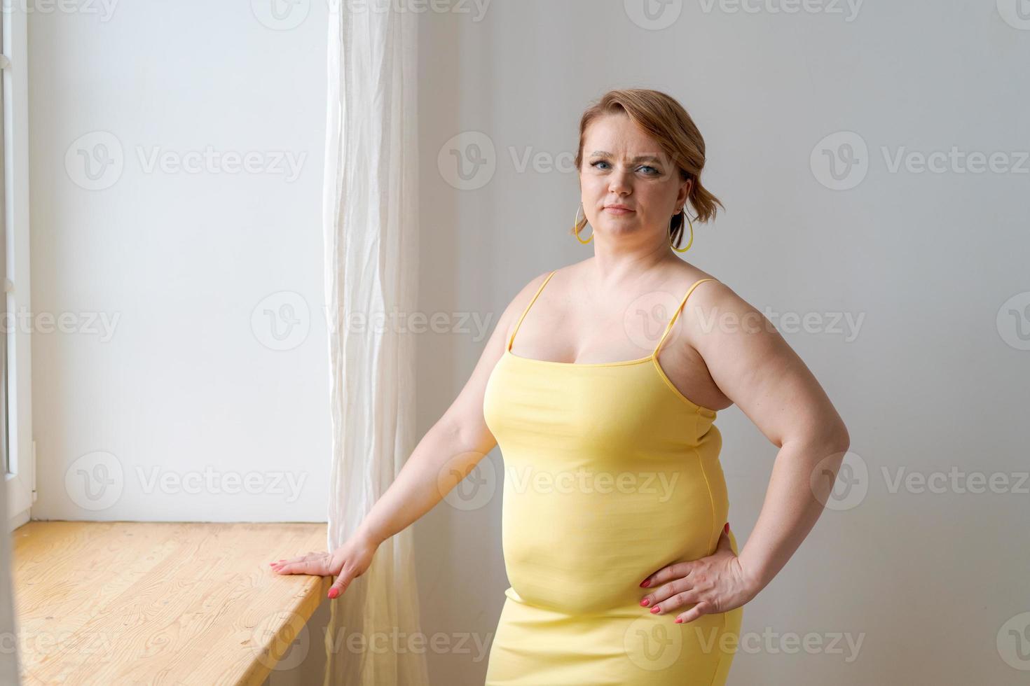 retrato alegre atractivo joven regordeta mujer tallas grandes xxl en vestido amarillo foto