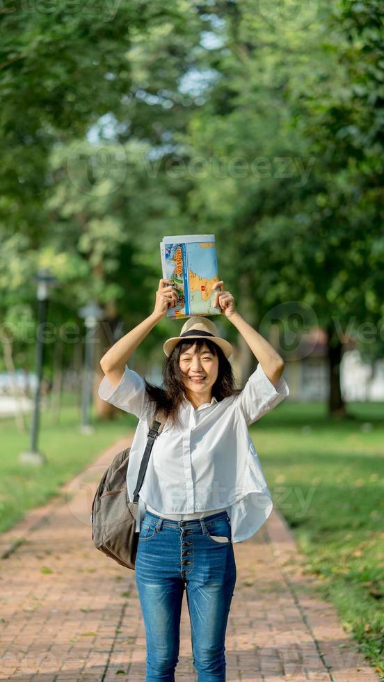 Happy tourist woman on vacation with map visiting temple photo