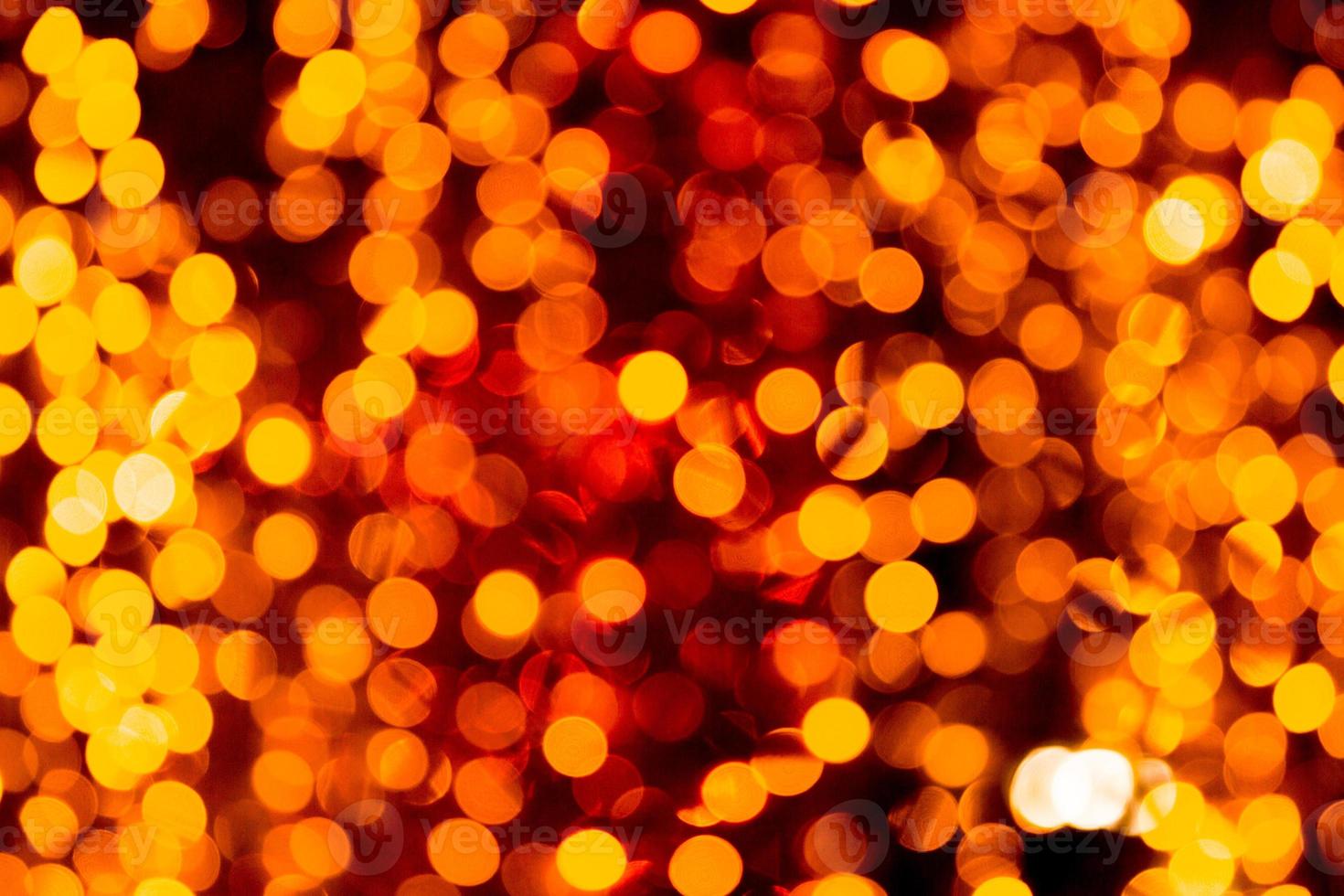 Festive abstract gold background with bokeh defocused and blurred many round yellow light on Christmas dark background photo