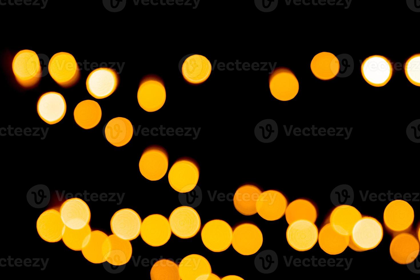Defocused city gold night bokeh abstract background. blurred many round yellow light on dark background photo