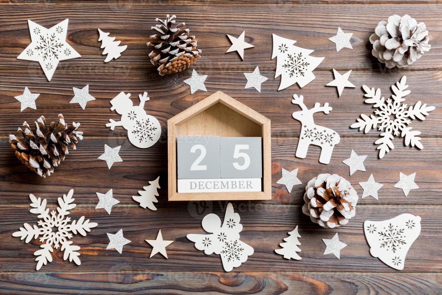 Top view of calendar on Christmas wooden background. The twenty fifth of December. New Year toys and decorations. Holiday concept photo