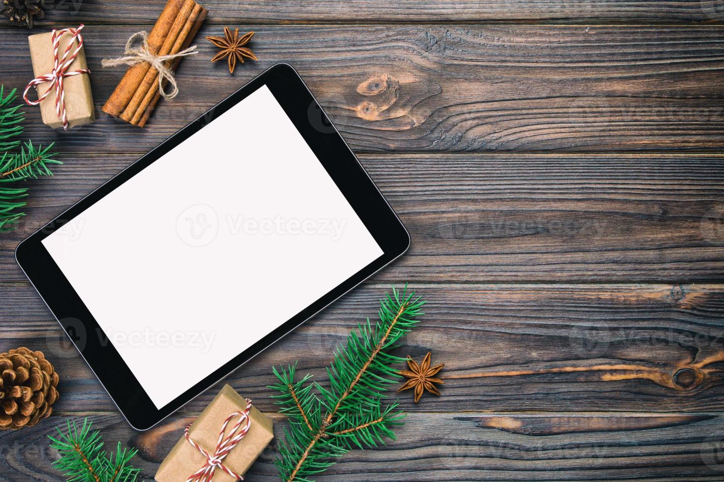 Digital tablet mock up with rustic vintage, toned Christmas wooden background decorations for app presentation. top view with copy space photo