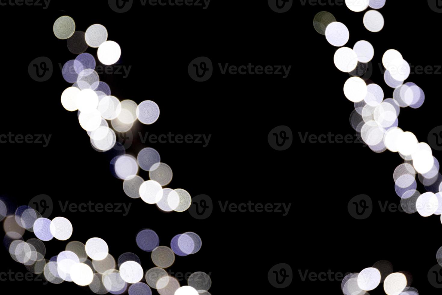 Unfocused abstract white bokeh on black background. defocused and blurred many round light photo