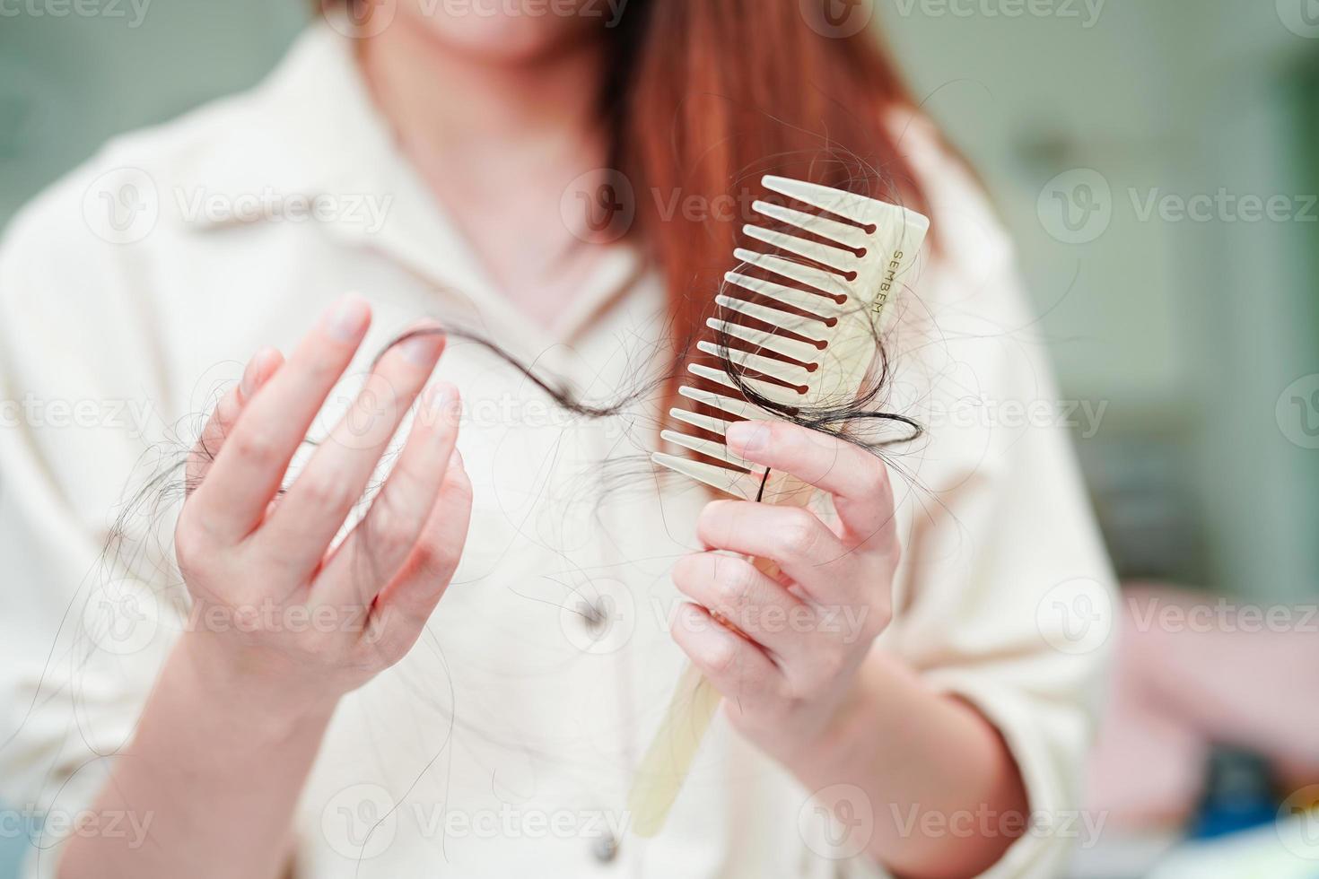 Asian woman have problem with long hair loss attach to comb brush. photo