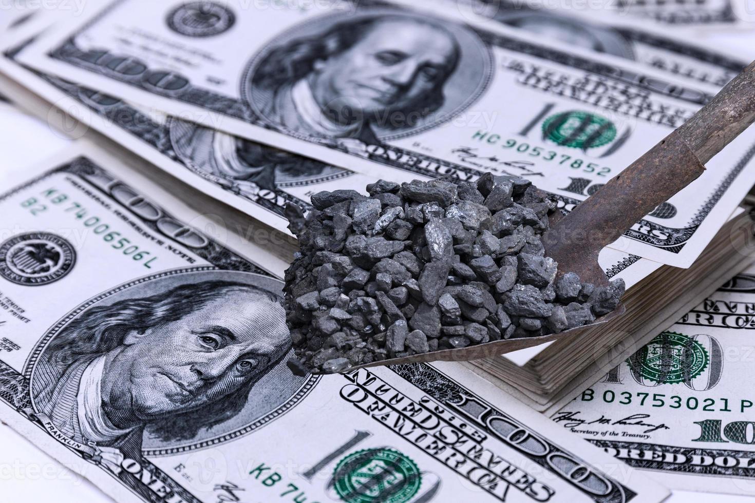 Shovel with black coal on the background of stacks of US dollars. Energy crisis. Selective focus. photo