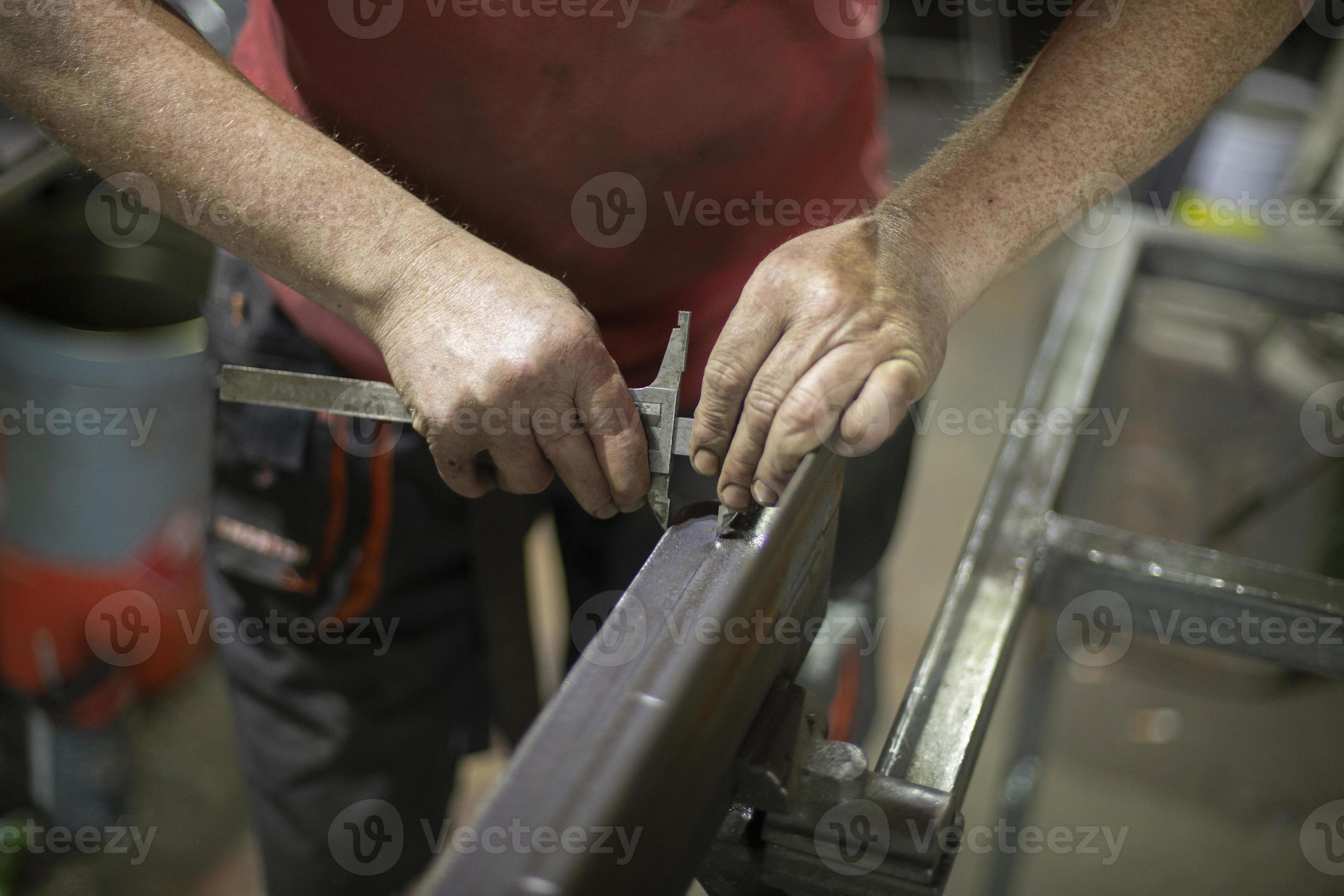 The worker works with metal. Construction tools, hands closeup. Work