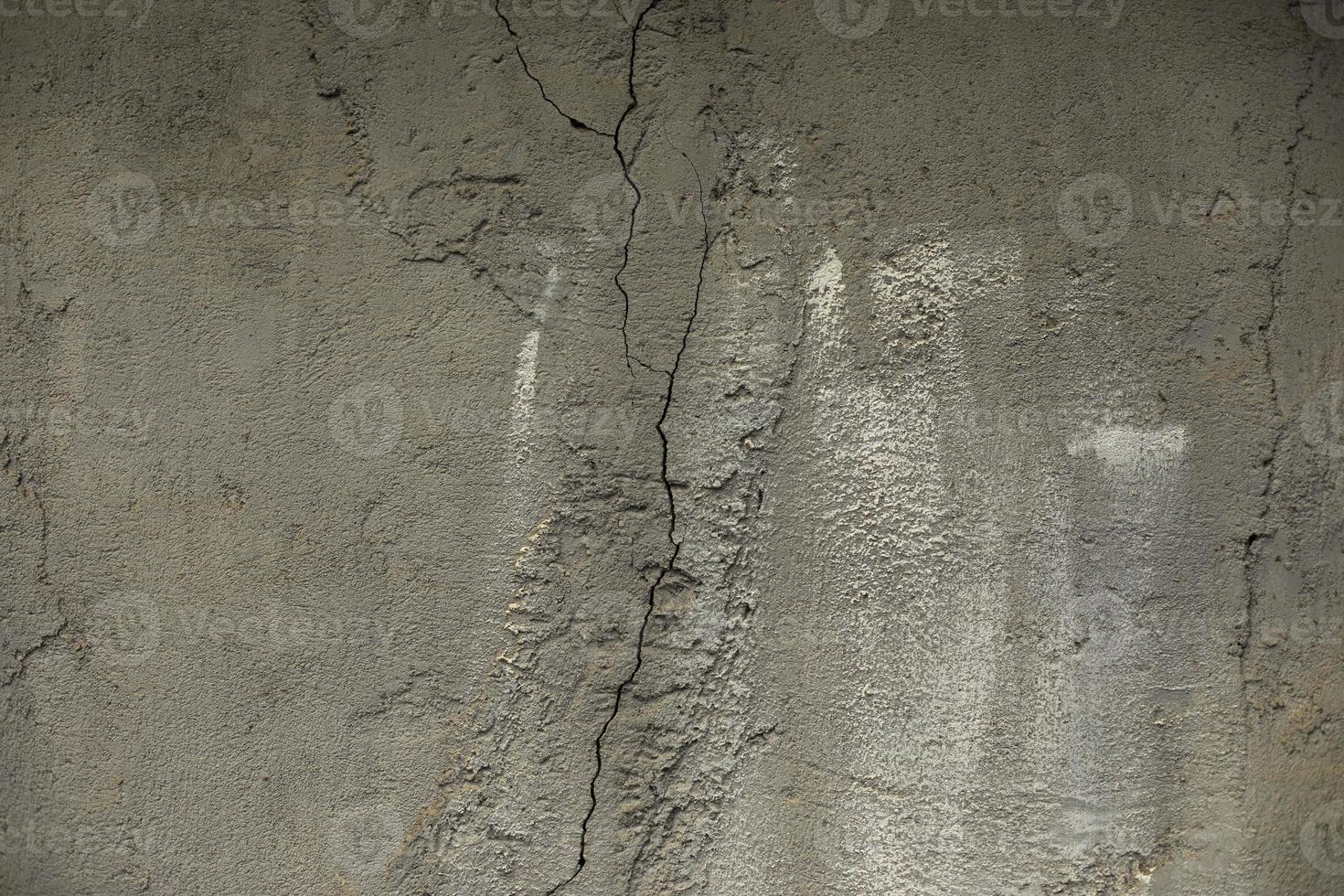 Cracked cement. Concrete wall without treatment. Surface details in cracks. photo