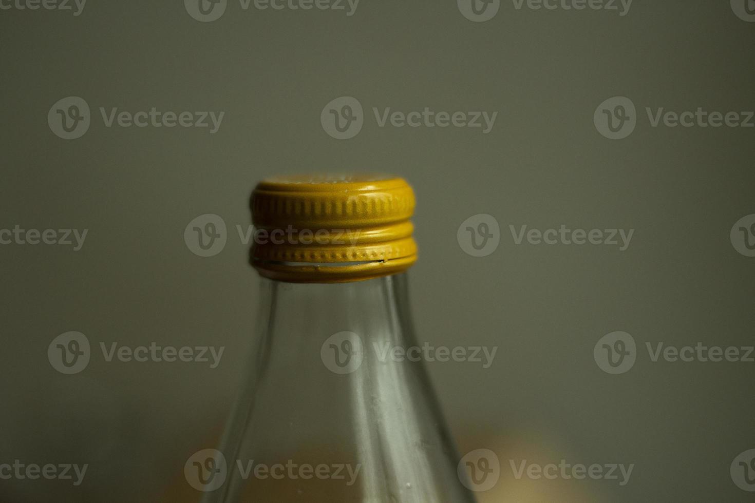 Yellow lid on a glass bottle. Glass water bottle. photo