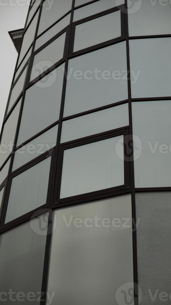 Tiles made of mirrors. Mirrored windows squares. Round building. photo