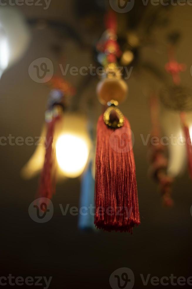 Red cloth hanging from ceiling. Thread brush. Interior decoration. Indian Decoration. Details of light in room. photo