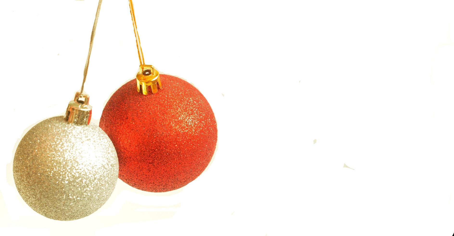bola de navidad roja y plateada colgando de una cinta sobre fondo blanco foto