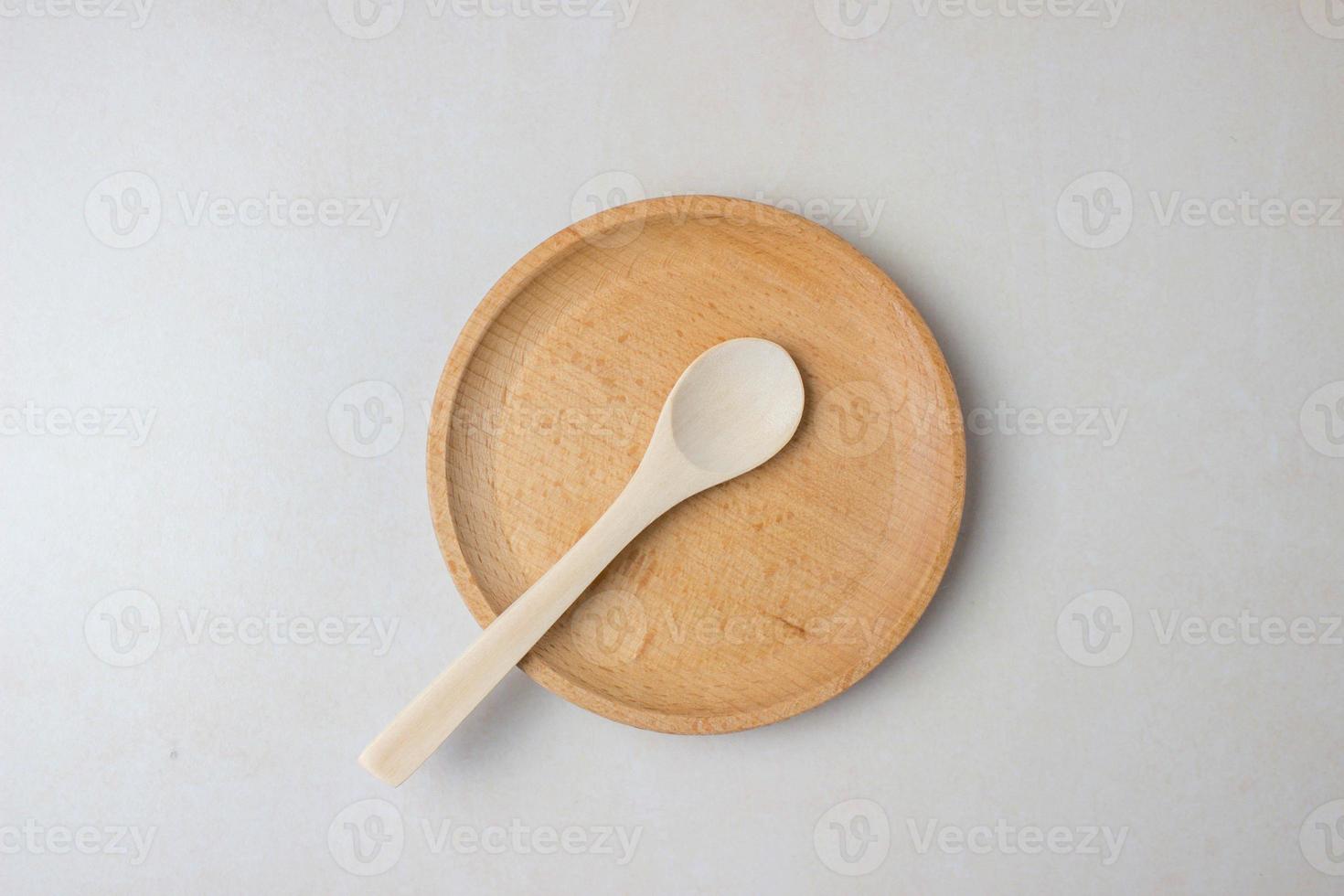 utensilios de madera en la mesa de la cocina. platos redondos de madera, una cuchara de madera. el concepto de servir, cocinar, detalles interiores. vista superior foto