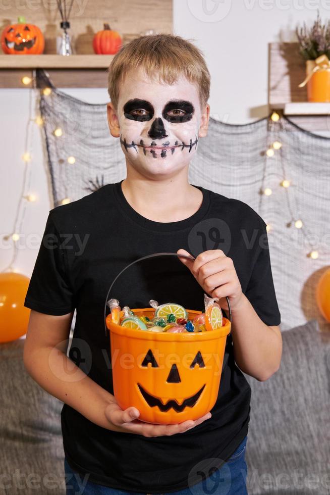 The child takes out the candy from the bucket for Halloween photo