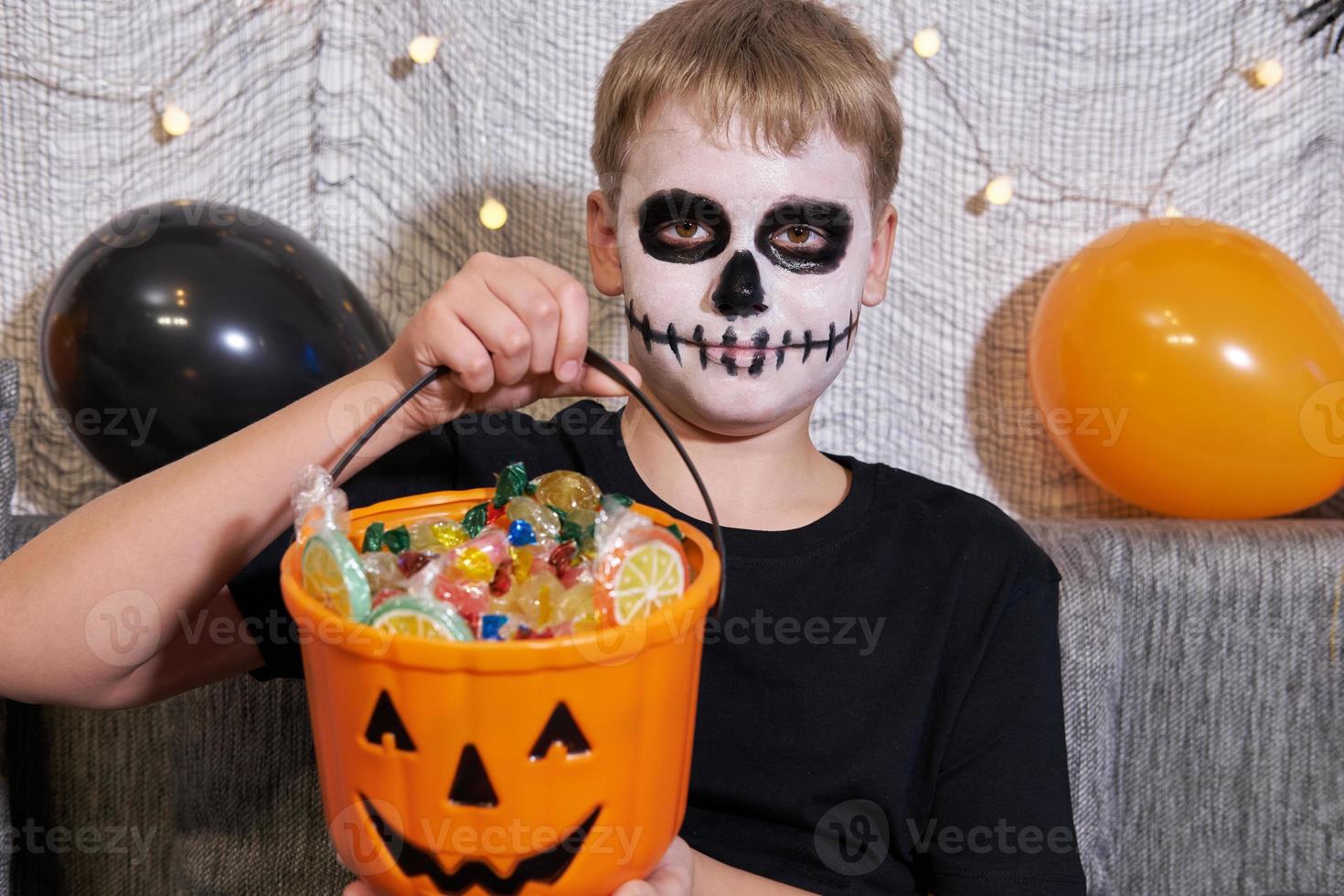 The child takes out the candy from the bucket for Halloween photo