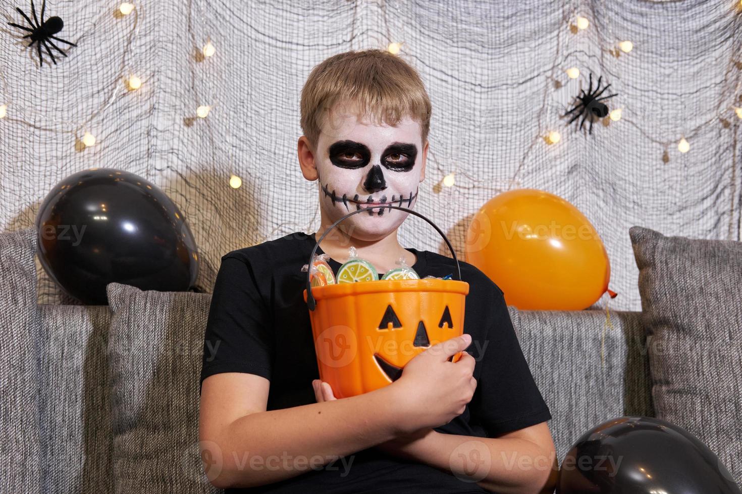 The child takes out the candy from the bucket for Halloween photo