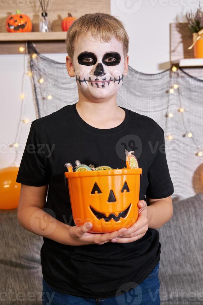 The child takes out the candy from the bucket for Halloween photo