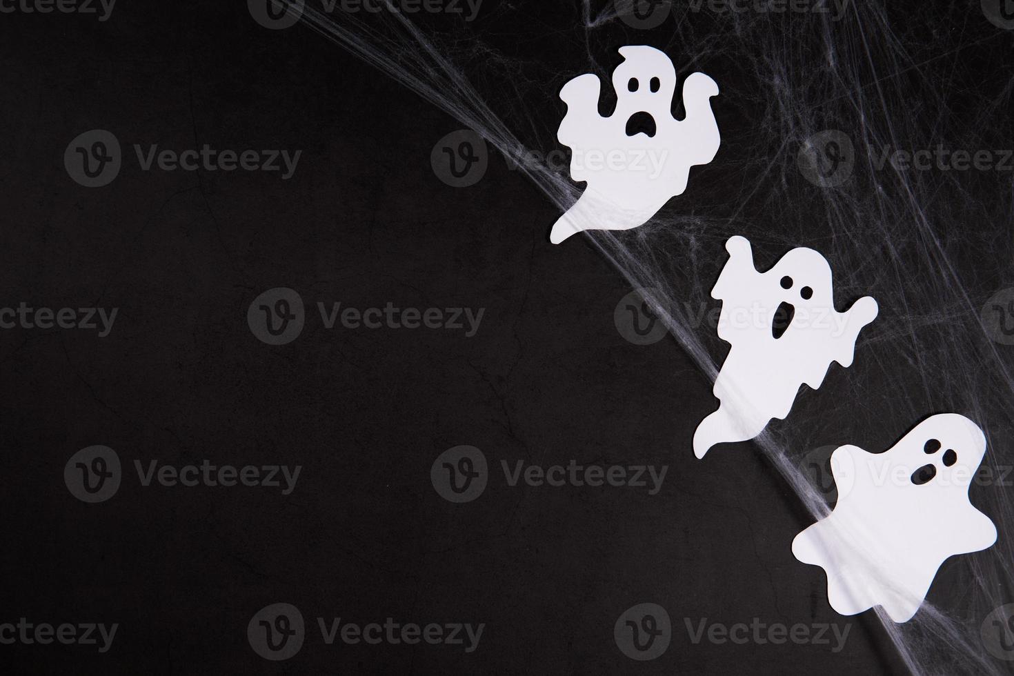 Spider web with ghosts on black background photo
