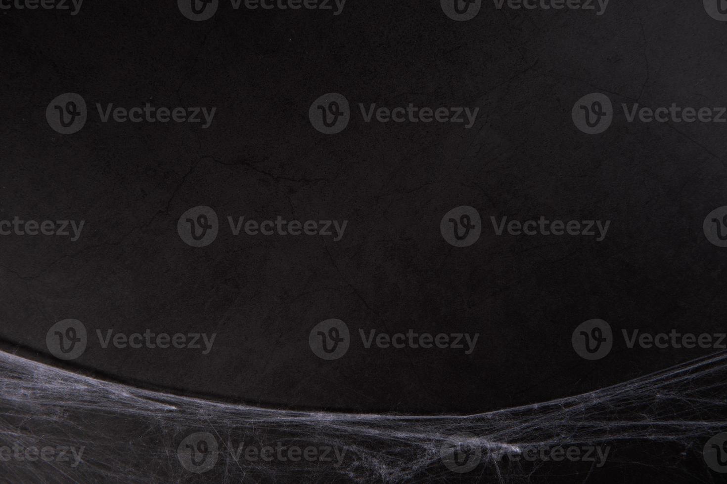 Grunge black paper background or texture with cobwebs for Halloween photo