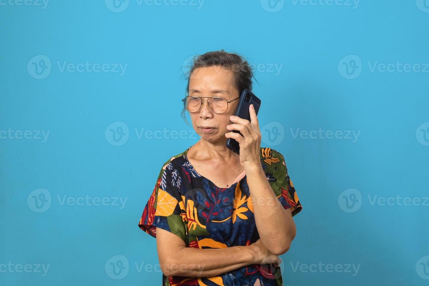 Elderly woman using mobile smartphone technology communications on background. photo