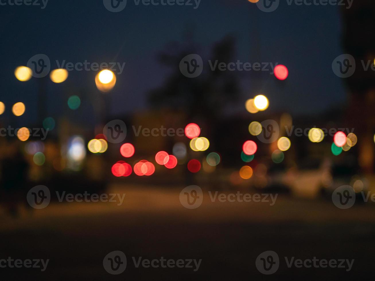 Defocused view on a evening crosstown traffic with traffic lights. Blurred city street view. photo