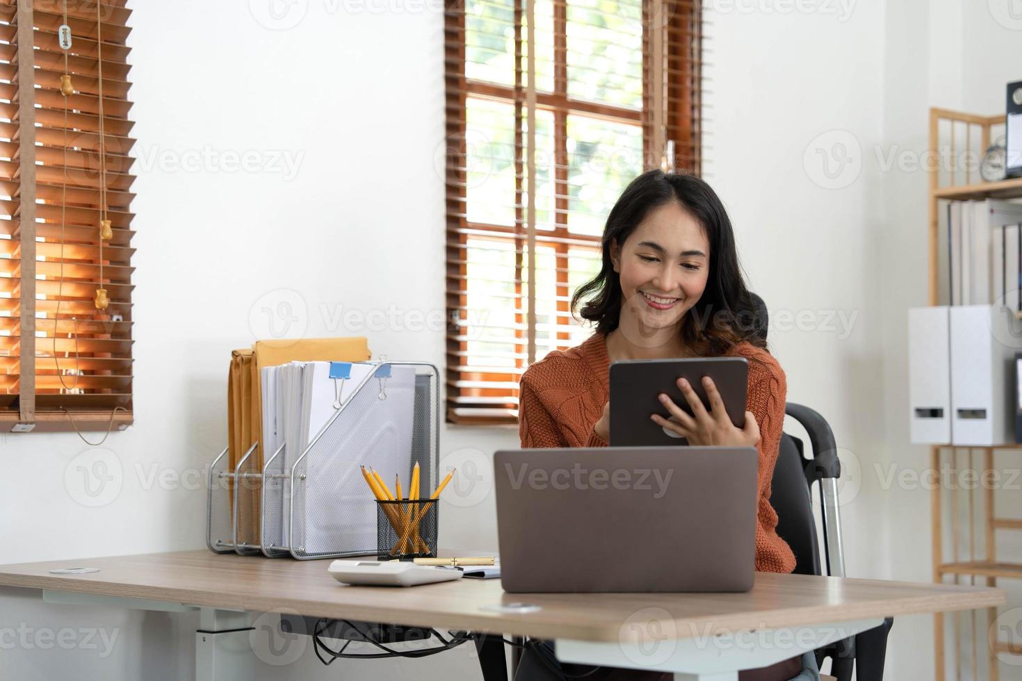 Smiling asian woman stand using modern pad gadget at home browsing Internet or shopping, happy satisfied young female client surf web read news or chat on tablet device, technology concept. photo