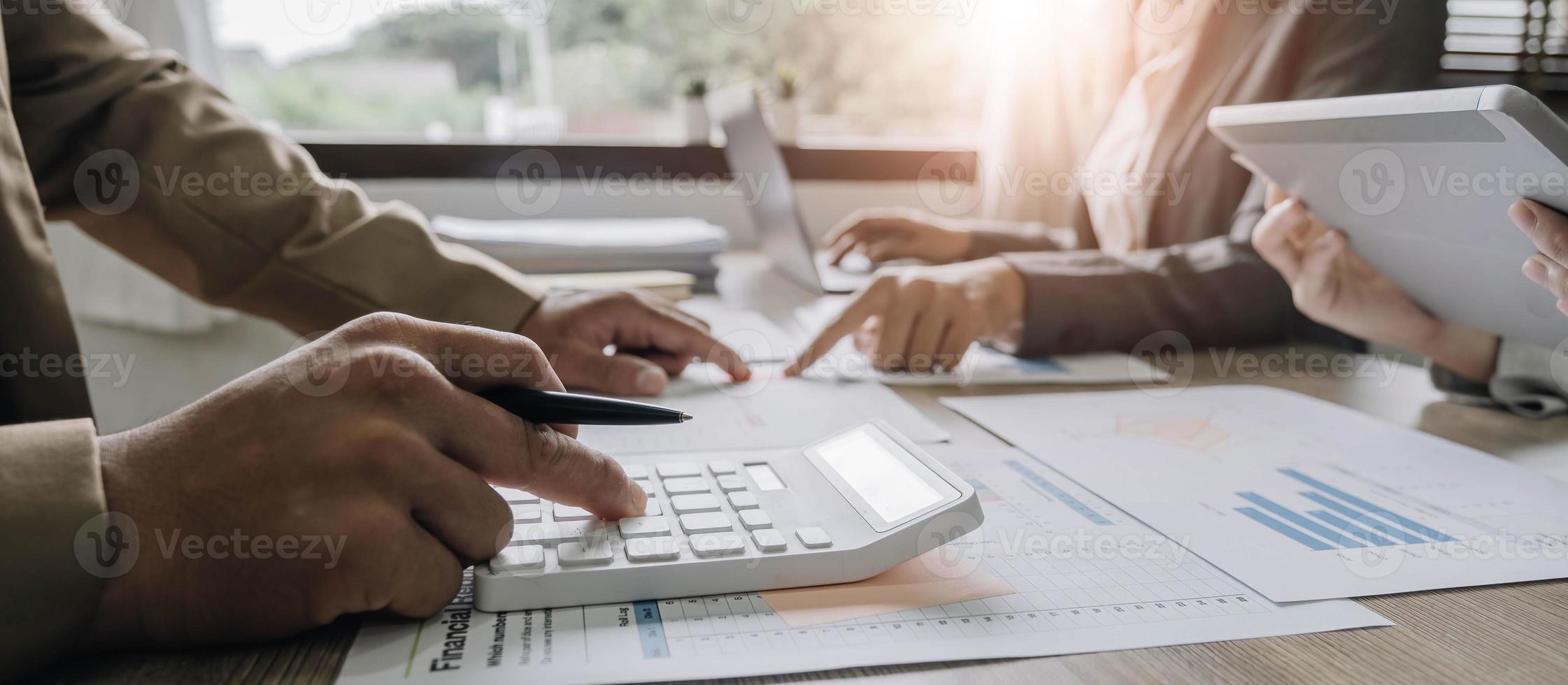 Close up Businessman and partner using calculator and laptop for calaulating finance, tax, accounting, statistics and analytic research concept photo