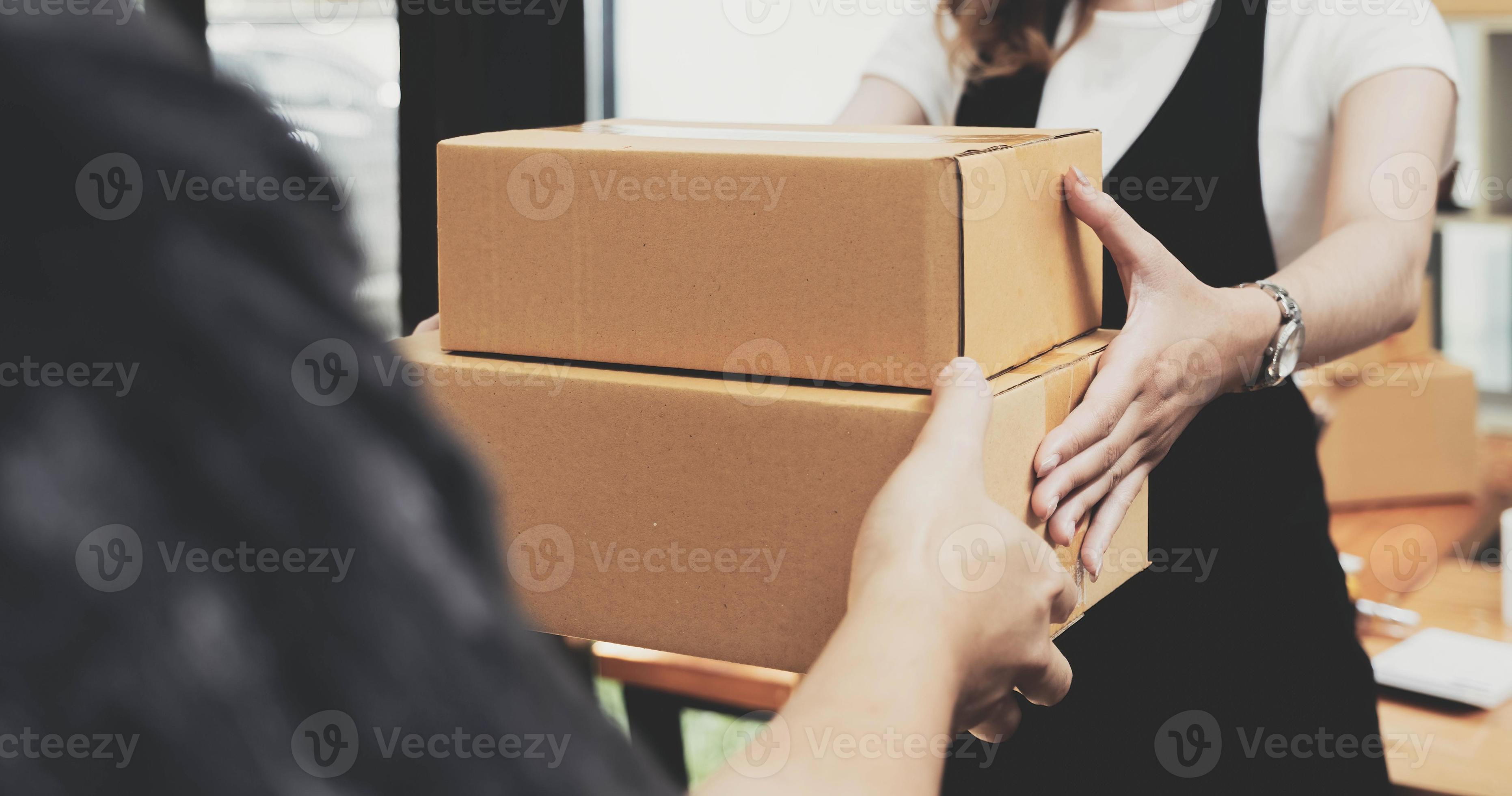 Closeup female hand accepting a delivery of boxes from deliverywoman